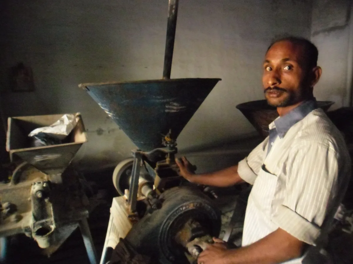 Worker operating a flour mill machine in India