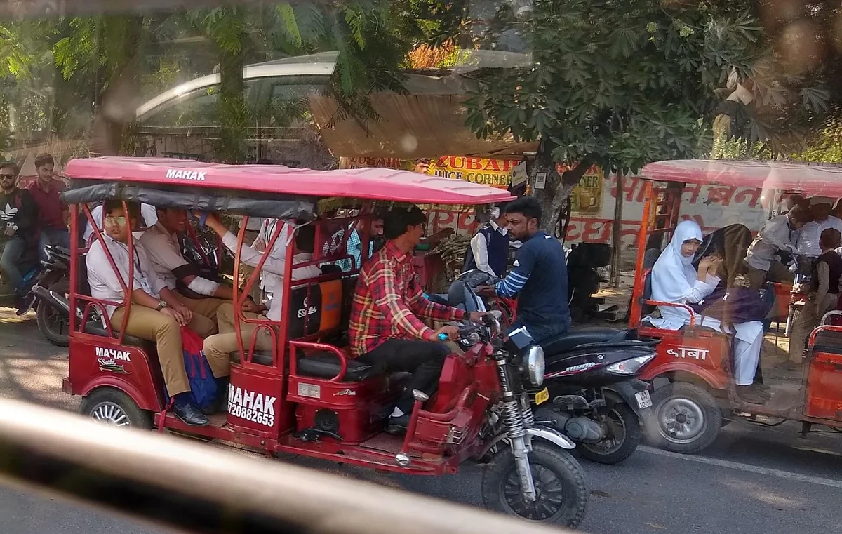Electric rickshaws carrying passengers on a street in Aligarh, Uttar Pradesh