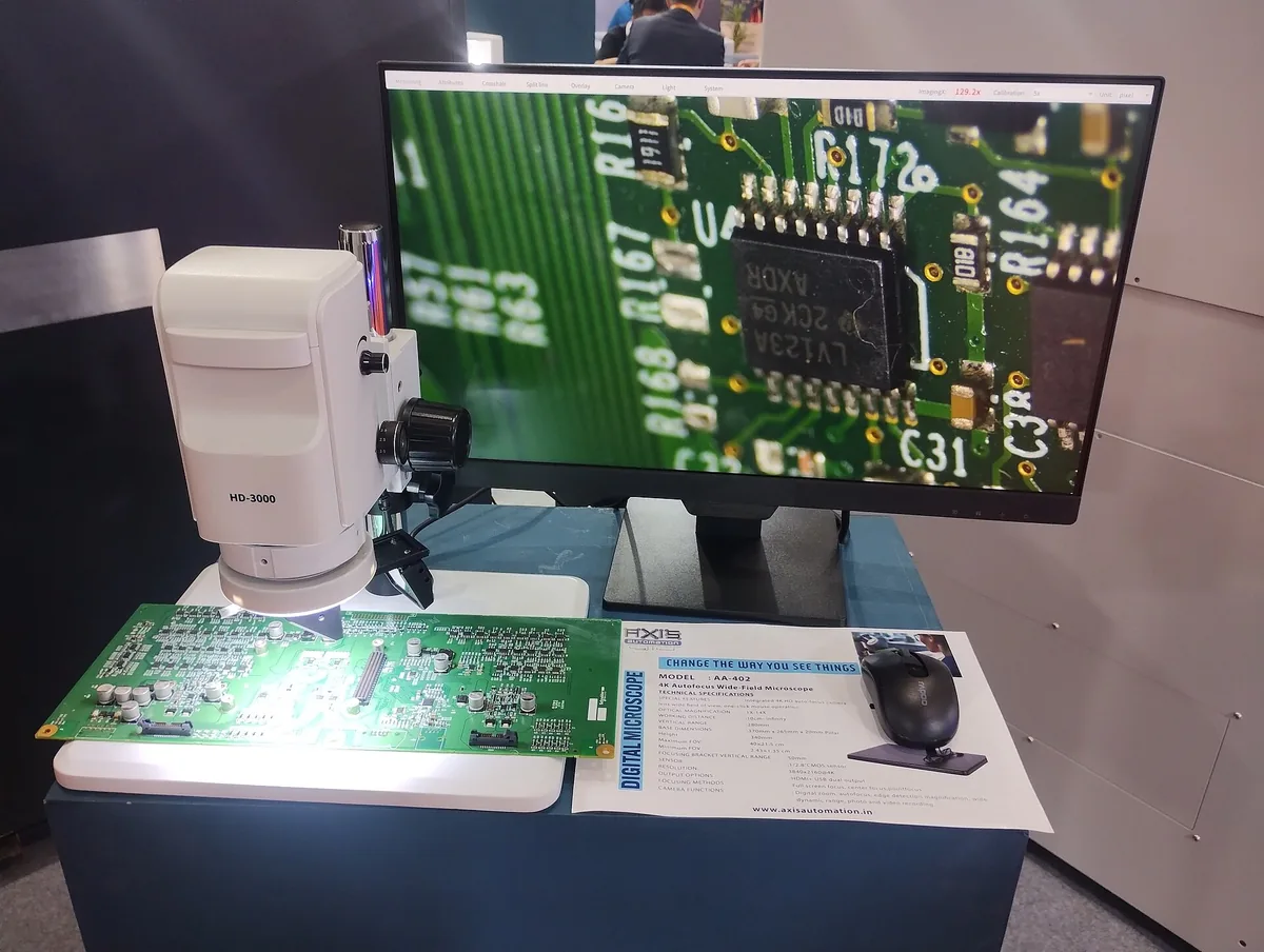 Printed circuit board under a digital inspection microscope at an electronics exhibition in Bengaluru