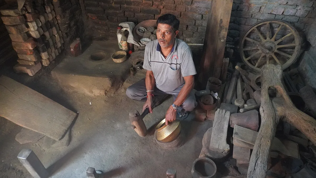 Brass craftsman at work in a small utensil workshop in Punjab
